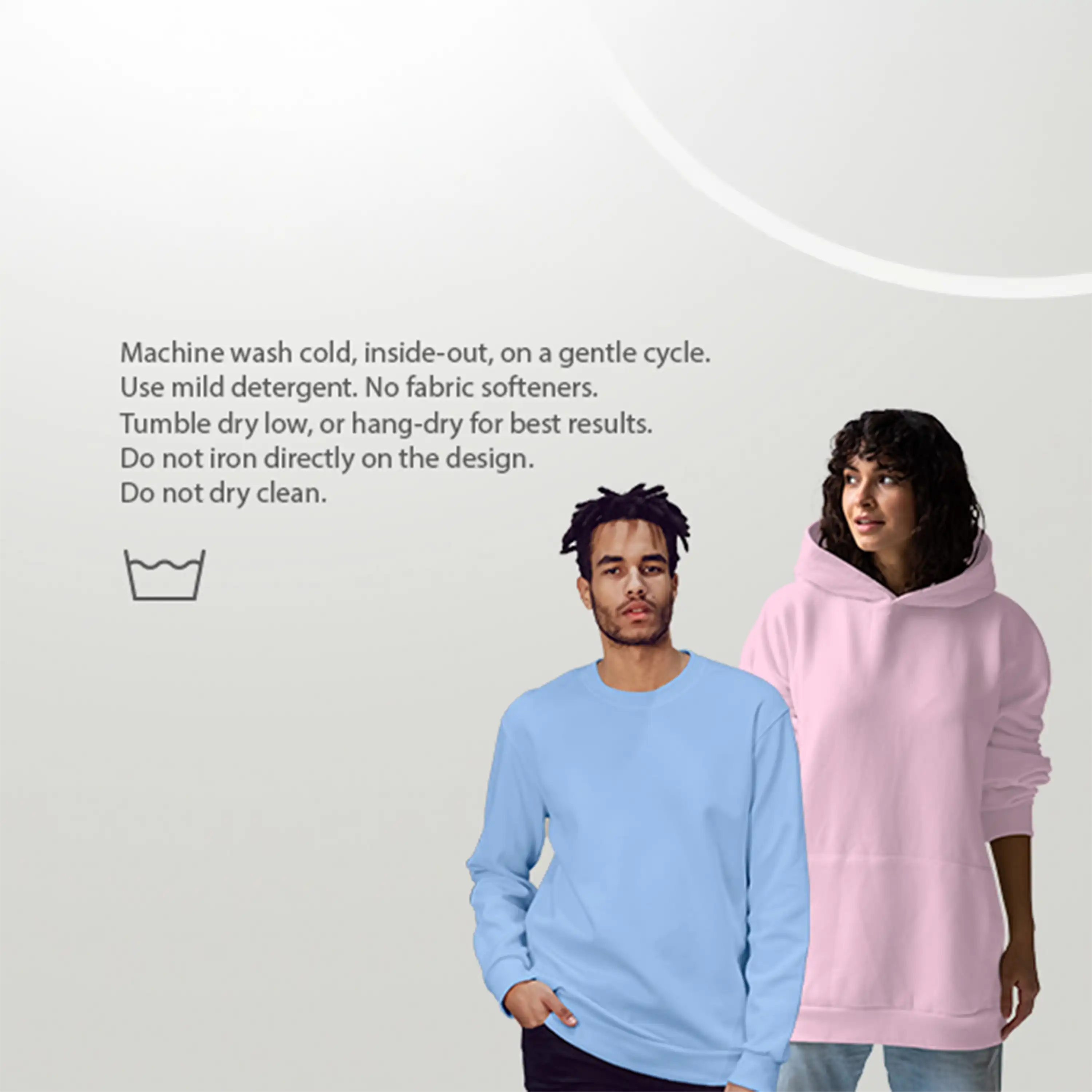 Two people wearing light blue and pink hoodies with washing instructions on a white background.
