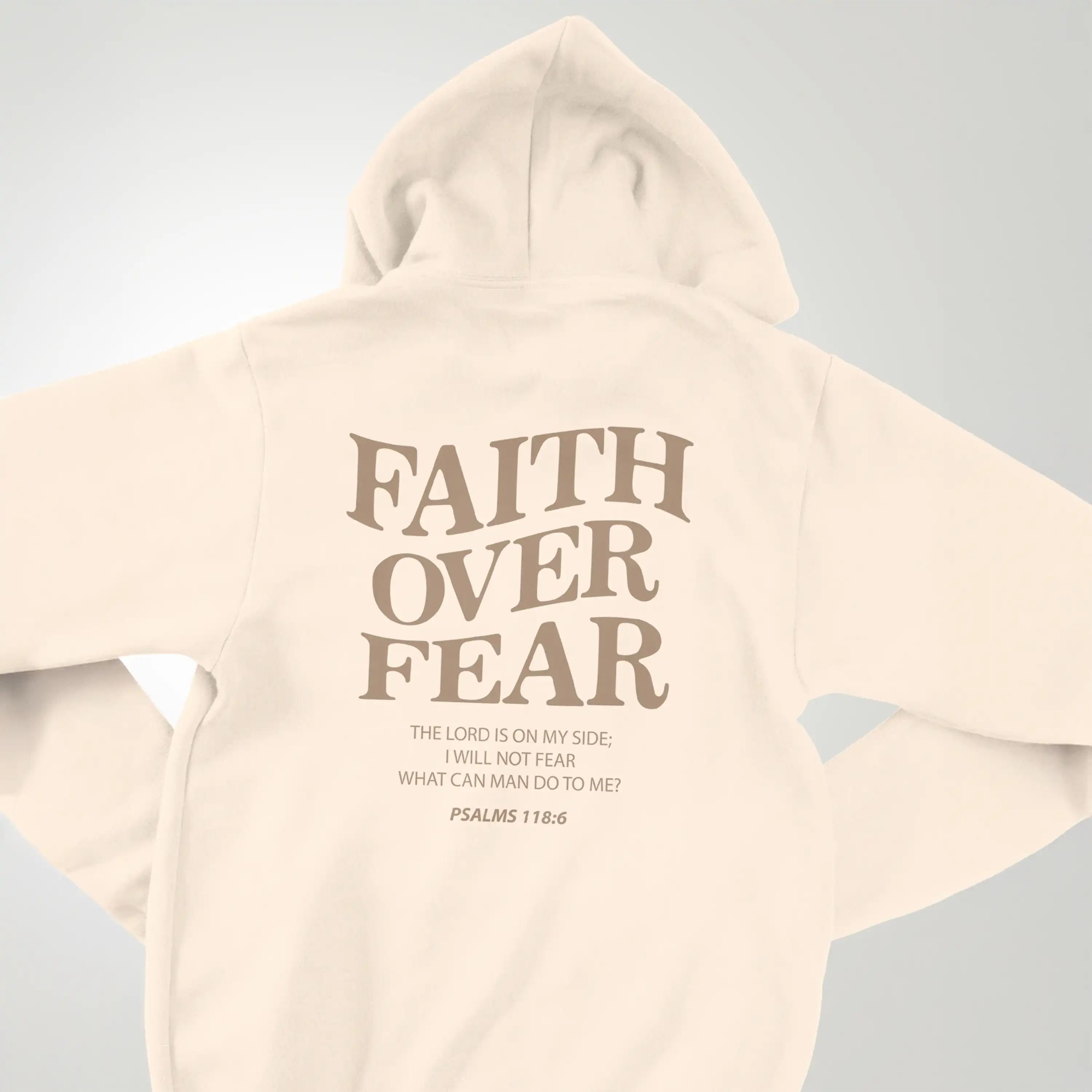 Beige hoodie with 'Faith Over Fear' text on a light gray background